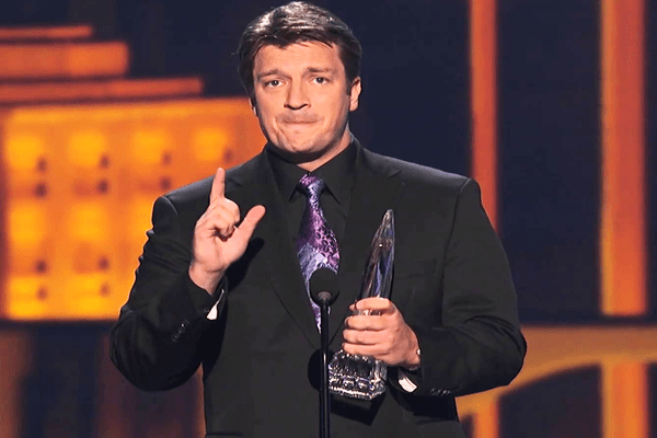 Nathan Fillion carrying trophy