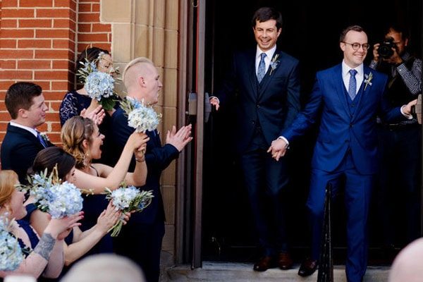 Chasten Glezman and Pete Buttigieg waving wedding guests